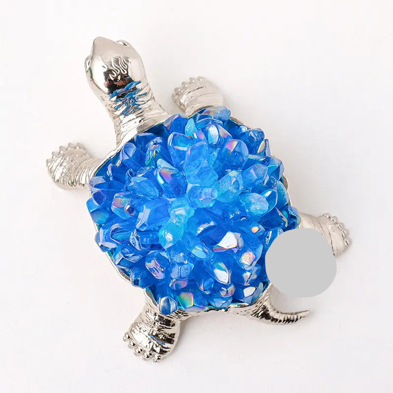 Decorative turtle figurine with blue bead shell on a white background