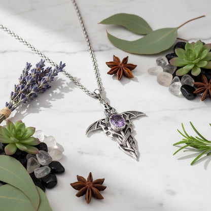 Silver pendant with a purple gemstone on a white background