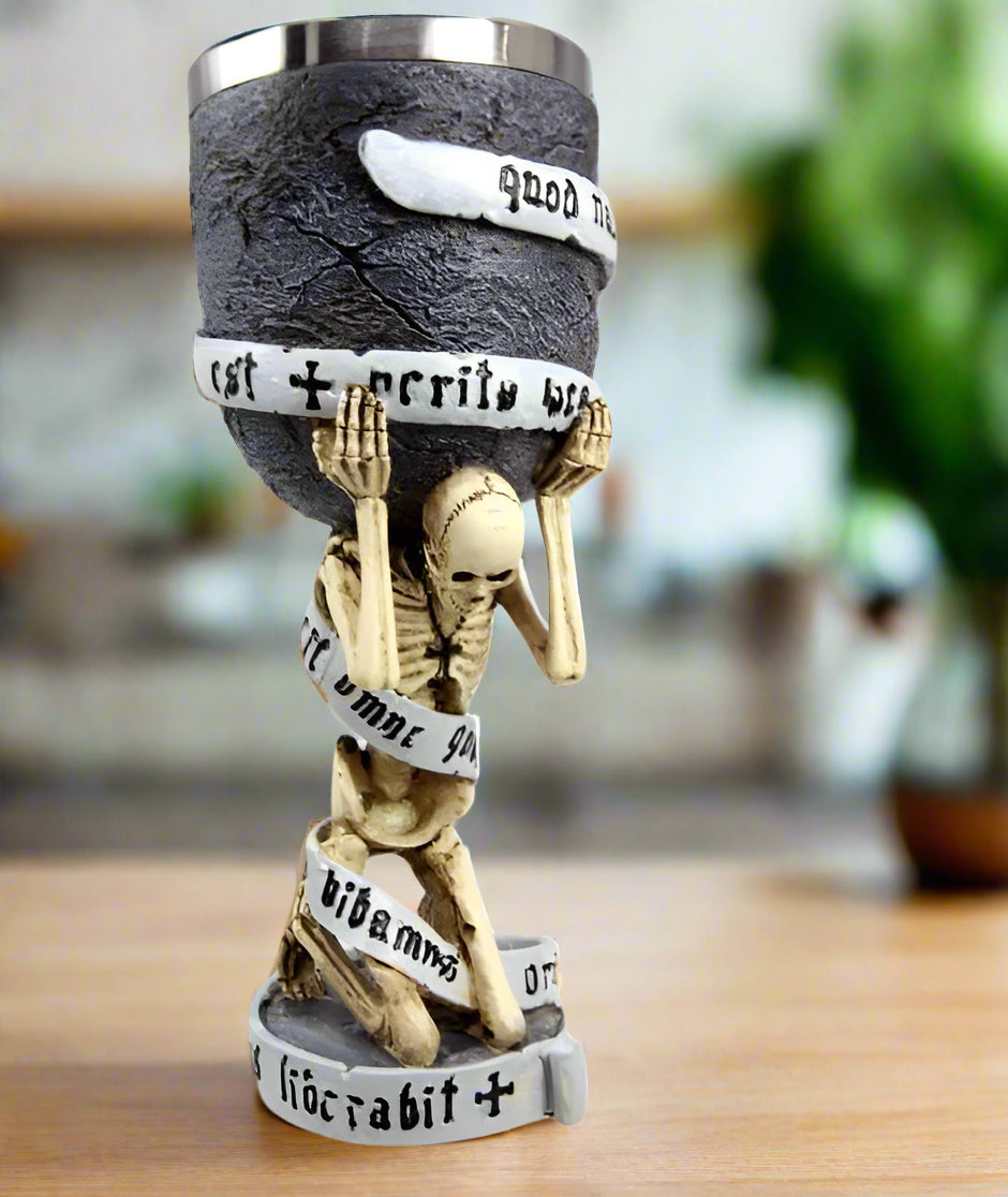Statue of a skeleton holding a cup with text bands on a white background