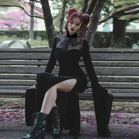 witch in a black dress sitting on a bench with a blurred background