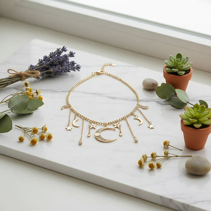 Gold necklace with moon and star charms worn by a person