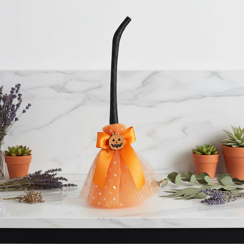 Halloween-themed decorative item with a black cane, orange bow, and pumpkin face on a white background