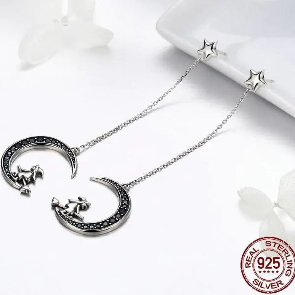 Silver necklace with moon and star design on a white background, featuring 'Real Sterling Silver' stamp.
