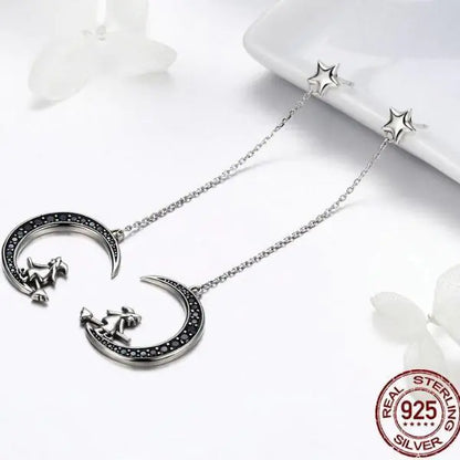 Silver necklace with moon and star design on a white background, featuring 'Real Sterling Silver' stamp.