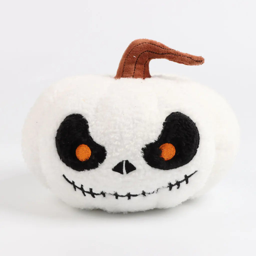 White plush pumpkin with black eyes and a brown stem on a white background