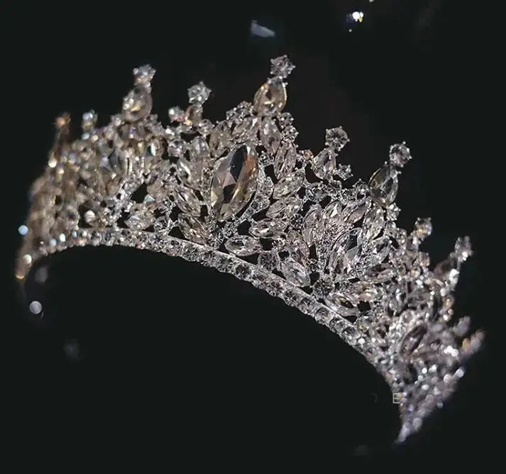 Silver tiara with intricate design on a black background