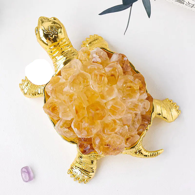Decorative turtle figurine with gold shell on a white background