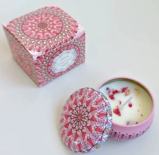 Pink patterned candle in a tin with a matching box on a white background