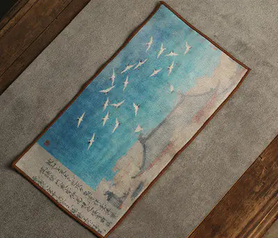Decorative rug with artistic design of birds flying over water on a textured surface.
