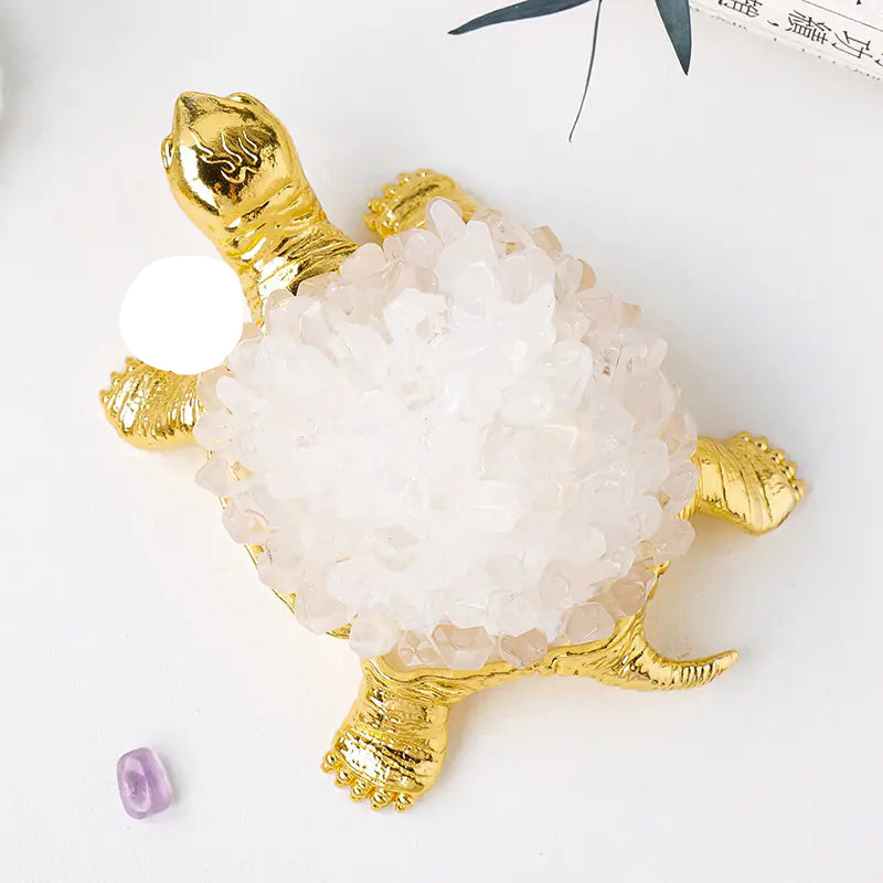 Decorative turtle figurine with gold accents on a white background