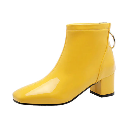 Yellow ankle boot with a block heel on a white background