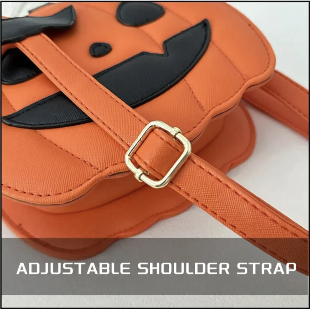 Orange pumpkin-shaped bag with a black face design and gold buckle on an adjustable shoulder strap.