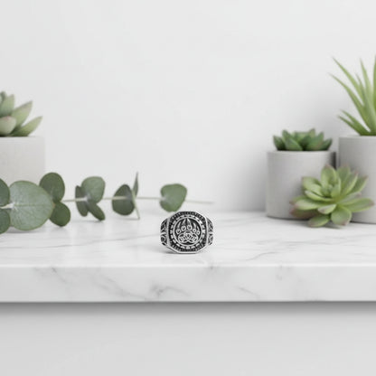Silver ring with paw print design on a gray background