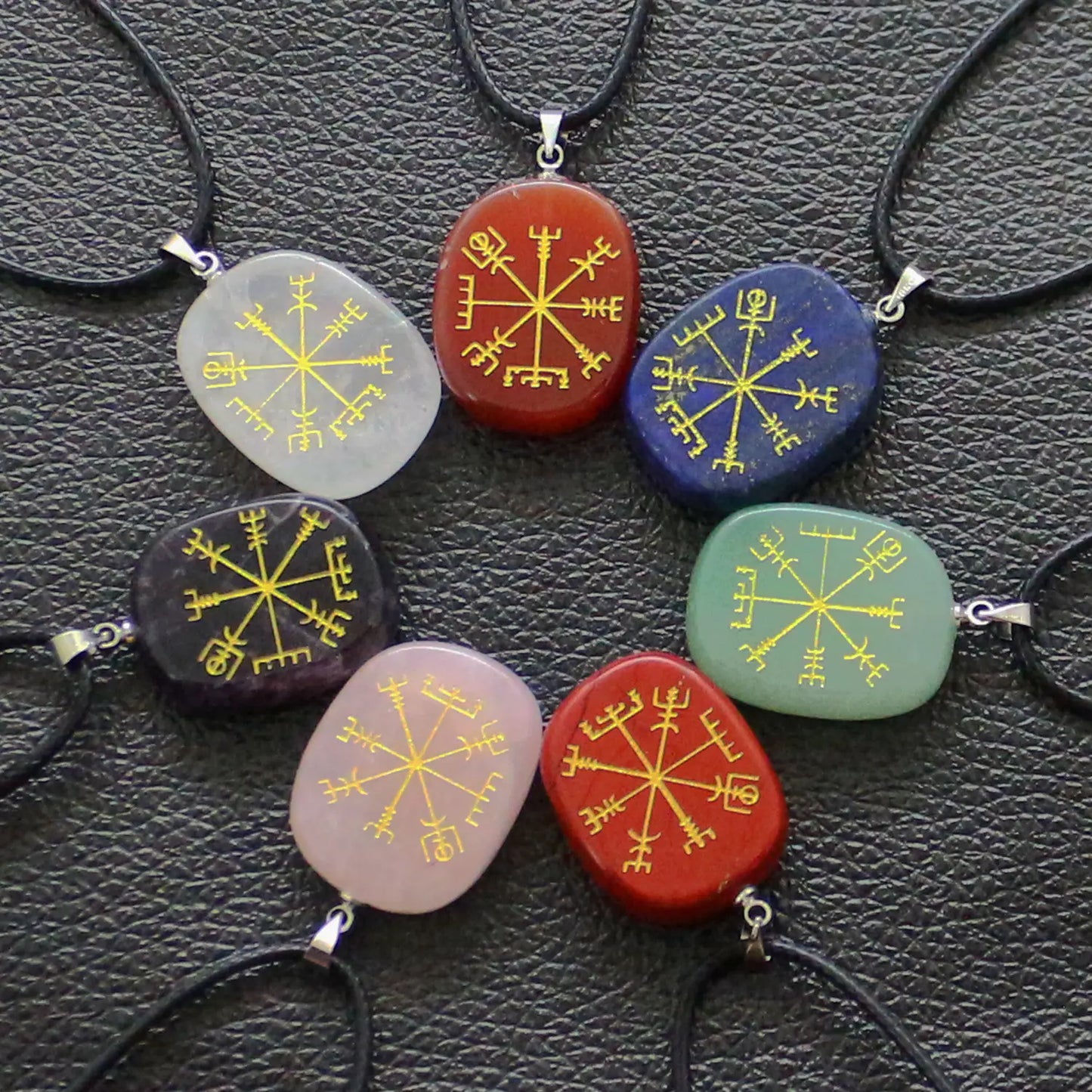 Set of colorful stone pendants with star designs on a textured surface