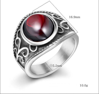 Silver ring with a red gemstone and measurements on a white background