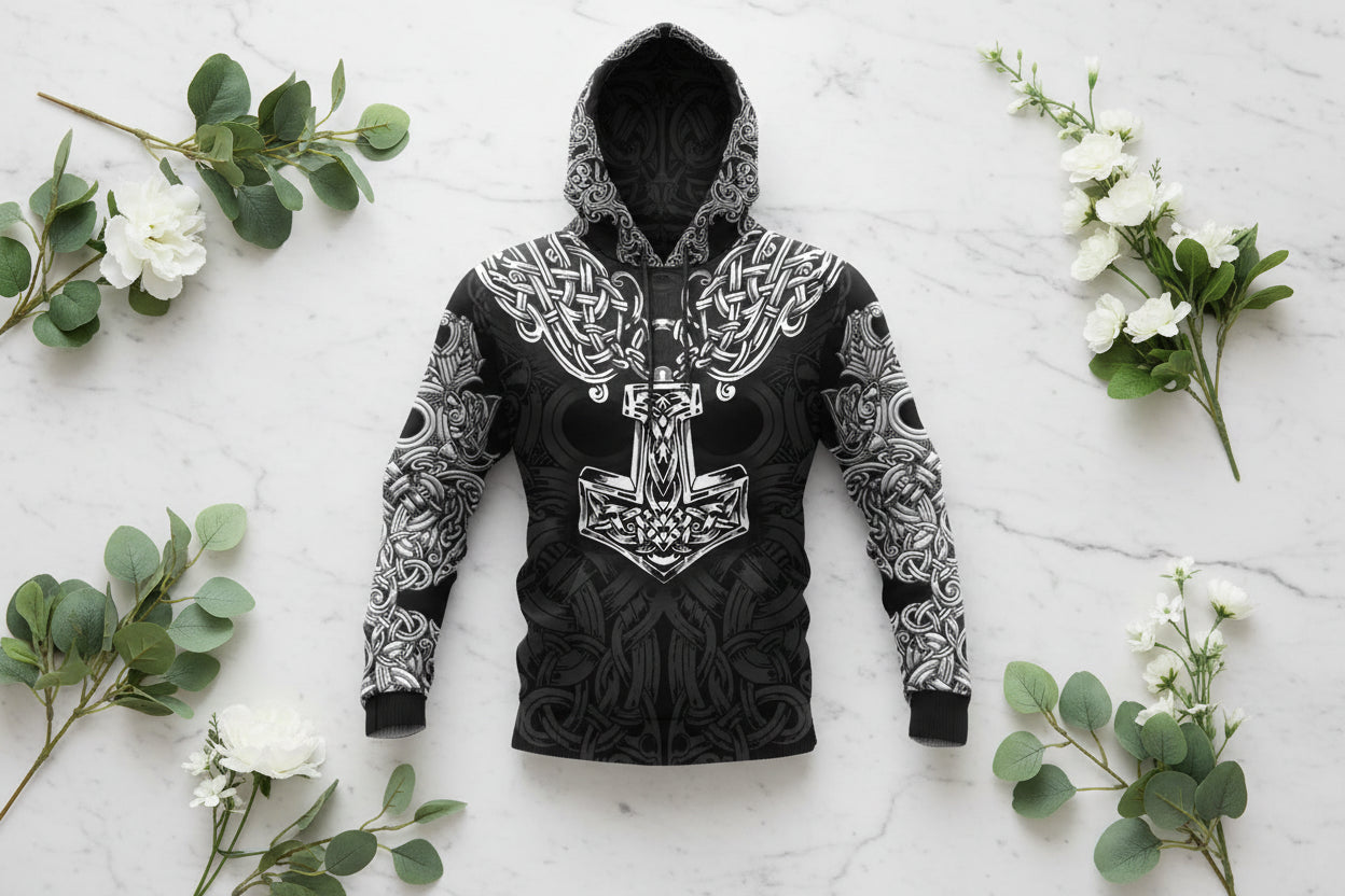 Black hoodie with white intricate designs and a prominent central emblem on a white background